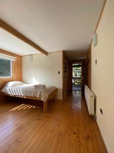 a bedroom with a bed and a wooden floor at Posada de Expediciones Kahuel in Chaitén +41 photos