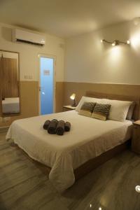 een slaapkamer met een groot bed met twee hoeden erop bij San Nikola Getaway in Sliema