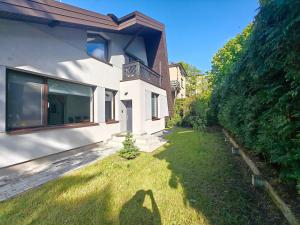 een schaduw van een persoon op het gras naast een huis bij Dom na Kasztanowej in Augustów