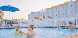 a group of children playing in a swimming pool at Patti's Inn and Suites in Grand Rivers