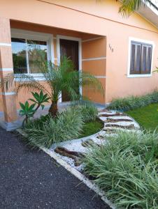 una casa con una palmera en el patio delantero en Cantinho da Ju, en Osório