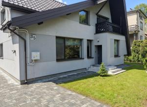 een wit huis met een zwart dak bij Dom na Kasztanowej in Augustów +46 foto's