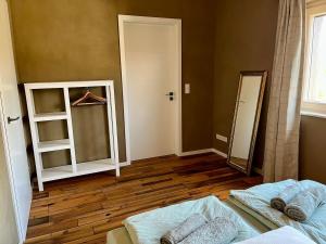 a room with a bed and a mirror and a closet at okoTime - Studio mit Dachterrasse in Birkenwerder