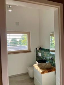 a bathroom with a sink and a toilet and a window at okoTime - Studio mit Dachterrasse in Birkenwerder