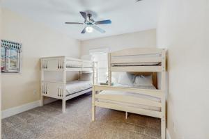 sypialnia z 2 łóżkami piętrowymi i wentylatorem sufitowym w obiekcie Barefoot Cottages D135 : Sandy Turtle w mieście Highland View