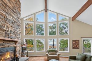 a living room with a fireplace and large windows at Mountain retreat w deck, game room & dog-friendly in Hedgesville +100 photos
