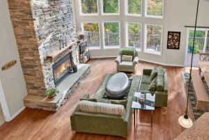 a living room with a large stone fireplace at Mountain retreat w deck, game room & dog-friendly in Hedgesville
