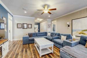 a living room with blue couches and a ceiling fan at Blue Pearl in Navarre