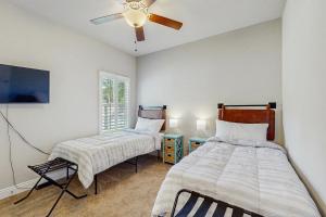a bedroom with two beds and a ceiling fan at Blue Pearl in Navarre +13 photos