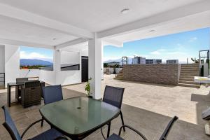 eine Terrasse mit einem Glastisch und Stühlen in der Unterkunft Sunlit Terra Haven at Pacifico Residencial in Jarretadera
