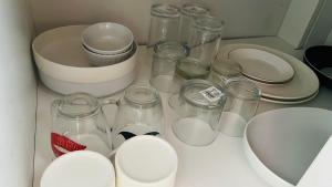 Un cajón lleno de tarros de cristal y platos sobre la encimera en Serene guesthouse, en Manzini 2 fotos más