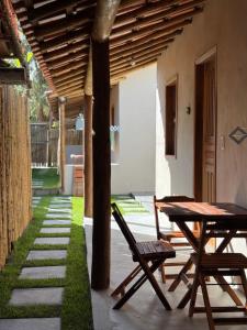 een patio met een tafel en een stoel naast een gebouw bij Vila Kairós in Caraíva