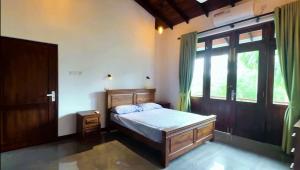 une chambre avec un lit et une grande fenêtre dans l'établissement The Penthouse Kadawatha, à Mahara