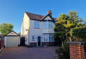 a white house with a garage on a driveway at Birkdale Open - modern 3 bedroom family home in Ainsdale