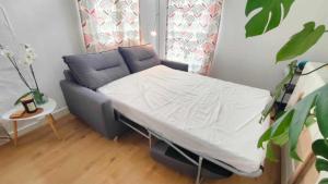 ein kleines Bett in einem Zimmer mit einem Sofa in der Unterkunft Studio Amboise, parking, terrasse et jardin in Amboise