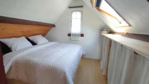 ein Schlafzimmer mit einem weißen Bett und einem Fenster in der Unterkunft Studio Amboise, parking, terrasse et jardin in Amboise