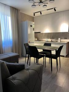 a living room with a table and chairs and a kitchen at Lucky House in Grigoleti