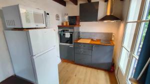eine Küche mit einem weißen Kühlschrank und einem Herd in der Unterkunft Studio Amboise, parking, terrasse et jardin in Amboise + 18 Fotos