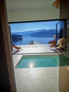 een zwembad in een huis met uitzicht op een meer bij Moon Lake Bicaz - Aurora Sky in Buhalniţa