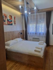 une chambre avec un lit avec deux serviettes dessus dans l'établissement Royal Garden Centar apartmani, à Zlatibor