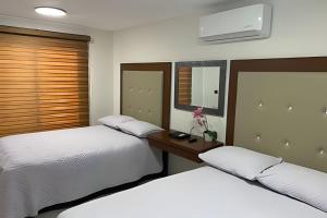 two beds sitting next to each other in a bedroom at Casa El Dorado - a 2 minutos de la Playa Miramar in Colonia Miramar