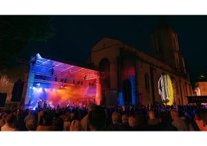 a crowd of people standing in front of a building at night at Hyper Centre Avec Terrasse in Tulle