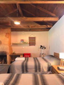 two beds in a room with wooden ceilings at cabaña de adobe las moras in San Mateo Río Hondo