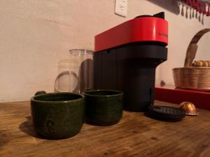 a red and black coffee maker on a wooden table at cabaña de adobe las moras in San Mateo Río Hondo