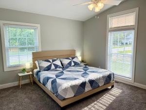 a bedroom with a bed and two windows at Cozy 3BR Retreat - Modern Finish & Great Location in Bettendorf