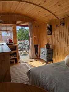 a bedroom with a bed and a stove in a room at Shepherd's hut Het Schoehuijs in Sint Maartensbrug