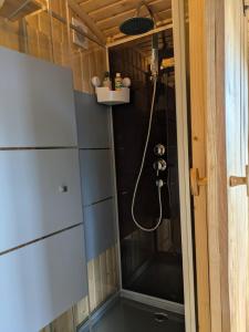 a shower with a hose in a small bathroom at Shepherd's hut Het Schoehuijs in Sint Maartensbrug