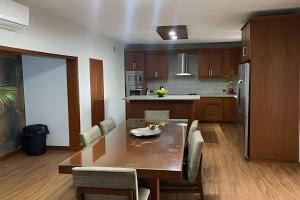 a kitchen with a wooden table and a dining room at Casa El Tular - Alberca priv / a 5 min de la playa in Colonia Miramar