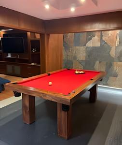 a pool table with a red cover in a room at Casa El Tular - Alberca priv / a 5 min de la playa in Colonia Miramar