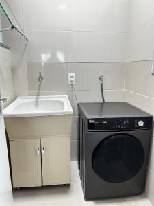 a kitchen with a sink and a washing machine at Casa moderna em Videira in Videira +3 photos