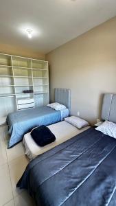 two beds sitting in a room at Casa moderna em Videira in Videira