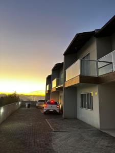 a car parked in a parking lot next to a building at Casa moderna em Videira in Videira