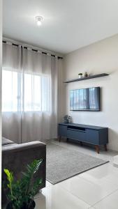 a living room with a couch and a tv on a wall at Casa moderna em Videira in Videira