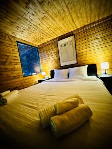 a bedroom with a large bed in a wooden wall at M Cabin Tree house Predeal Ciubar in Predeal