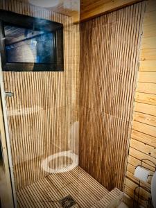 a bathroom with a shower with a wooden wall at M Cabin Tree house Predeal Ciubar in Predeal +25 photos