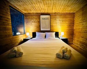 a bed in a wooden room with two pillows on it at M Cabin Tree house Predeal Ciubar in Predeal +22 photos