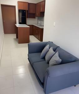 a blue couch in a living room with a kitchen at Casa Madre Perla - a 2 min de la Playa Miramar in Colonia Miramar +5 photos