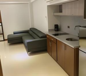 a living room with a couch and a kitchen at Loft El Tular - a 5 minutos de la Playa in Colonia Miramar