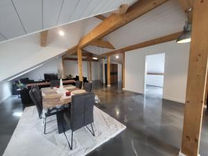a dining room with a table and chairs at Le loft in Villarsel-le-Gibloux