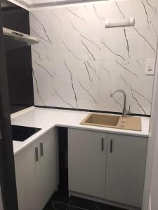 ヘウムにあるNoclegi Centrum Chełmのキッチン(シンク、白いカウンタートップ付)