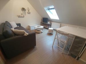 una sala de estar con un sofá y una mesa en Le Saint Georges, en Chinon