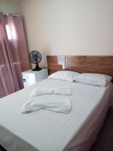 ein Bett mit weißen Decken und einem Ventilator darauf in der Unterkunft Pousada Recanto da Vila in Mucugê