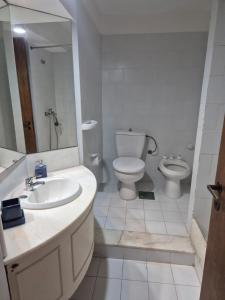 une salle de bains avec lavabo, toilettes et miroir dans l'établissement Club Sol, à Punta del Este