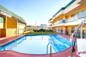 ein Schwimmbad vor einem Gebäude in der Unterkunft Homegate Studios & Suites San Antonio Medical Center in San Antonio