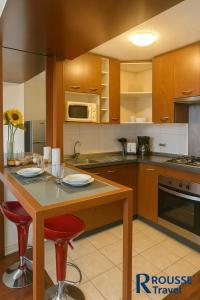 a kitchen with a table with chairs and a microwave at Rousse 9 Santiago in Santiago