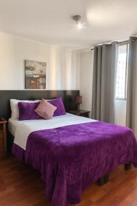 a bedroom with a purple bed with a purple blanket at Rousse 9 Santiago in Santiago